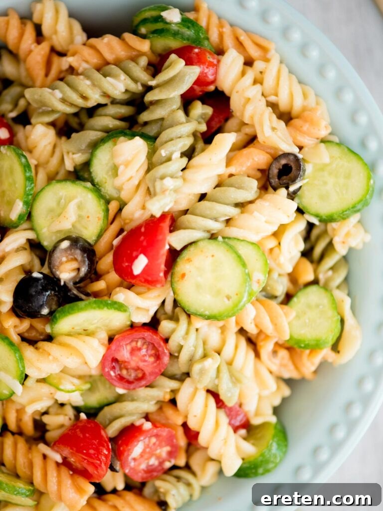 Closeup of a delectable Zesty Italian Pasta Salad, glistening with dressing and loaded with fresh ingredients
