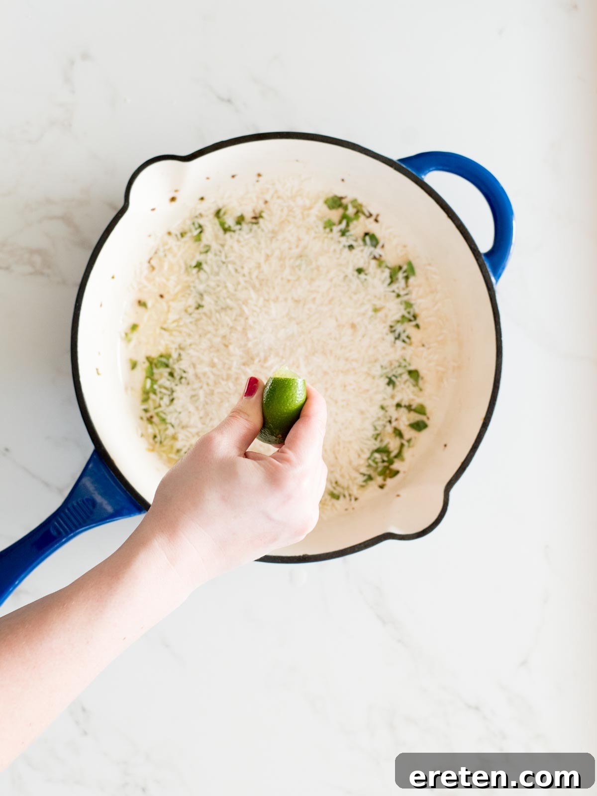 lime juice being squeezed into cast iron skillet