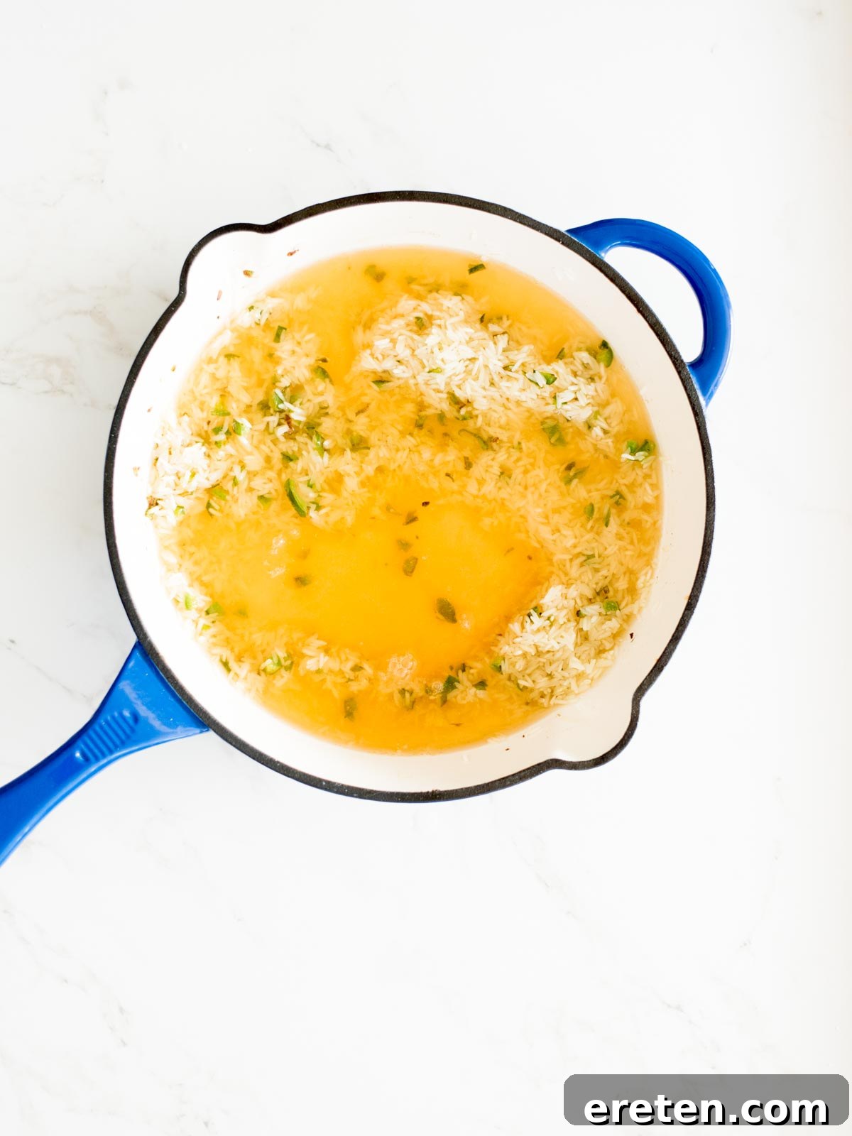 broth in skillet with rice and jalapeno