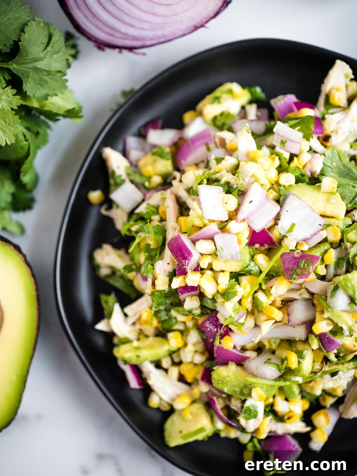 A close-up view of the Avocado Chicken Chopped Salad, showcasing the texture and even coating of the dressing.