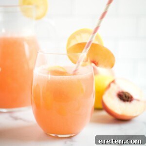 a glass of peach lemonade with a straw
