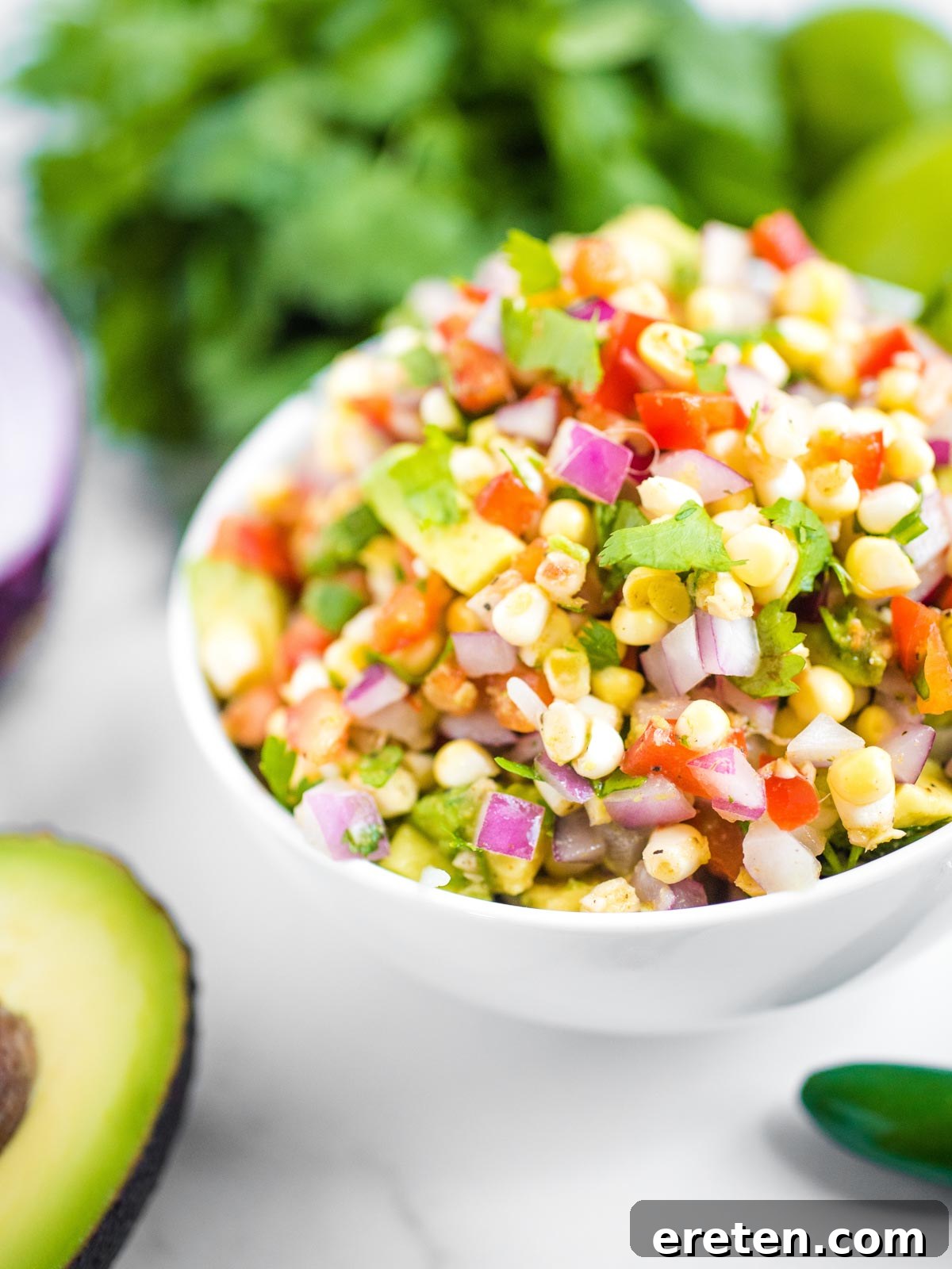 up close view of avocado corn salsa surrounded by additional ingredients