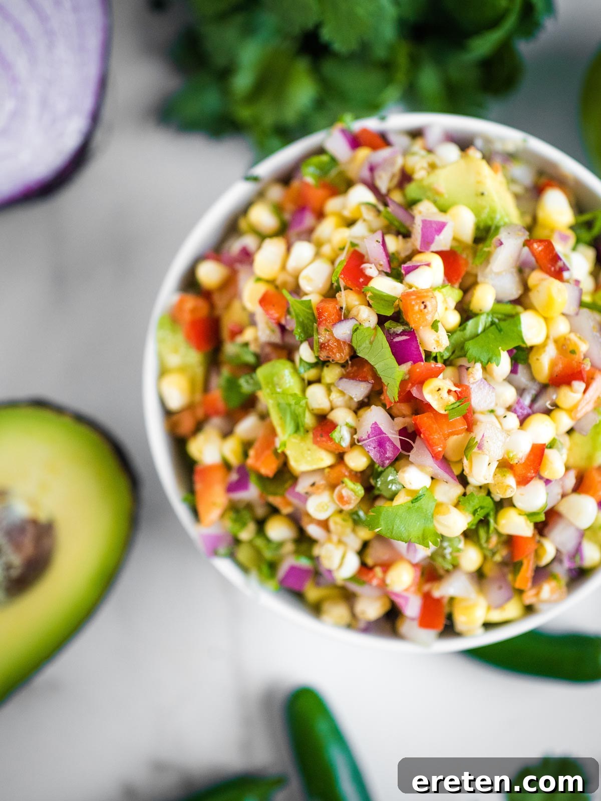 overhead shot of avocado corn salsa in a white bowl