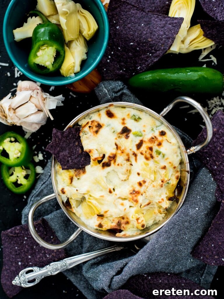 Spicy Artichoke Jalapeno Fusion 2 A vibrant and creamy Jalapeno Artichoke Dip, garnished with fresh herbs, served in a rustic ceramic bowl with tortilla chips.