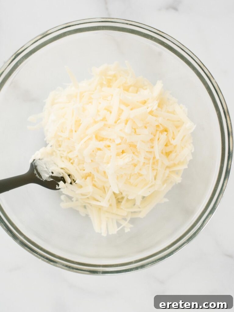 Spicy Artichoke Jalapeno Fusion 6 Grated Parmesan cheese being added to the cream cheese and mozzarella mixture.