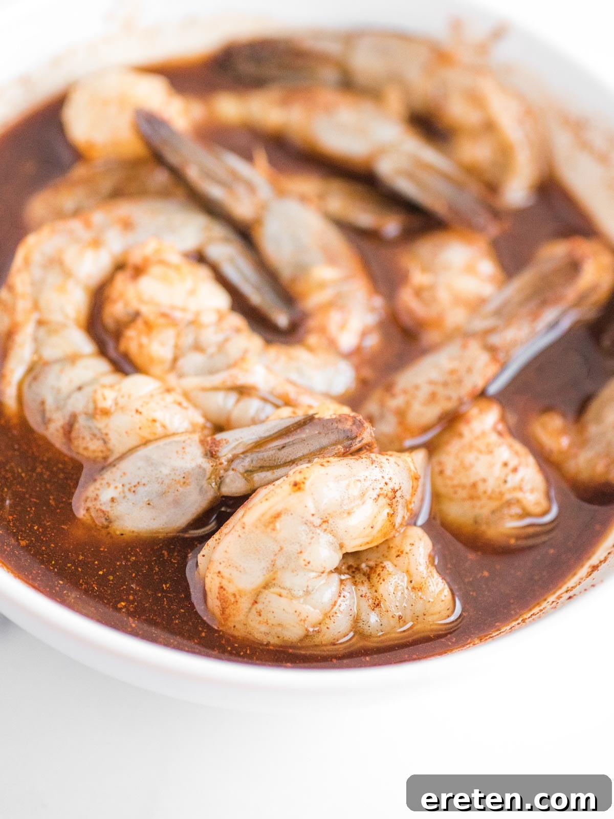 Bowl of shrimp marinating in a chili lime mixture