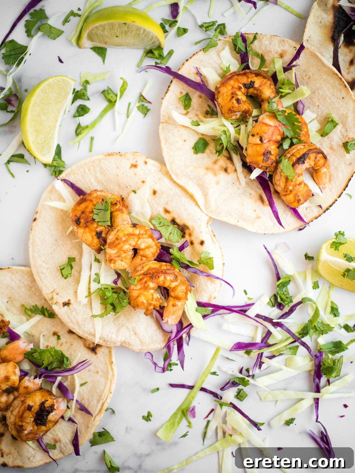 Overhead shot of chili lime shrimp tacos on a wooden board