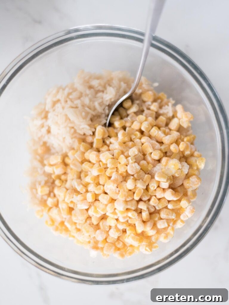 Mixing bowl with corn and rice in it, showing the start of the ingredient combination.