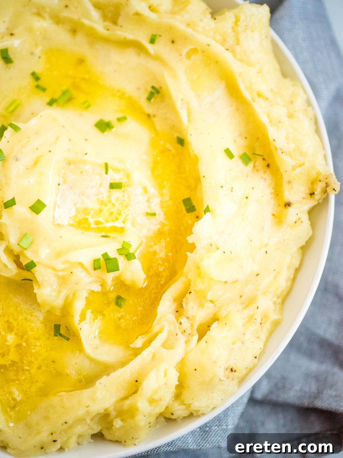 Fluffy mashed potatoes with melted butter in a white dish