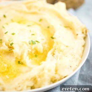 mashed potatoes in white dish topped with melted butter and chives