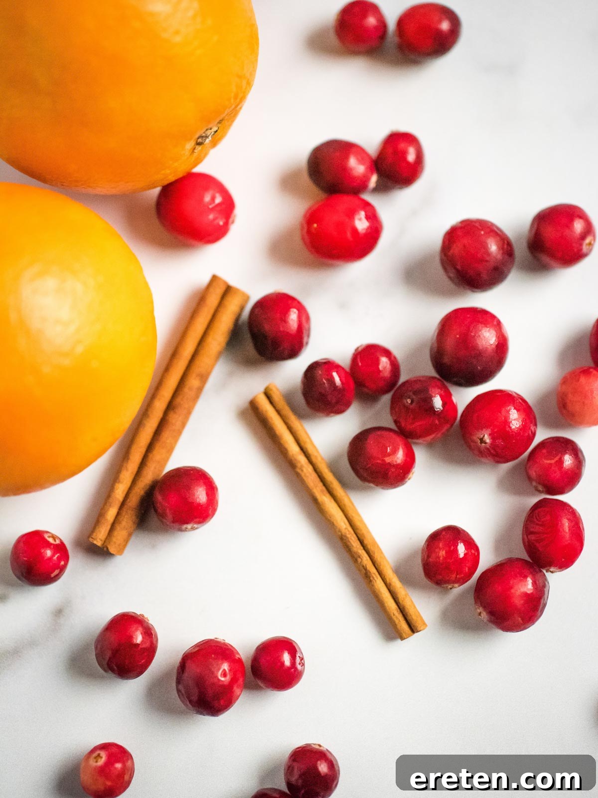Vibrant Instant Pot Cranberry Orange Sauce 3 oranges cinnamon sticks and cranberries on the surface