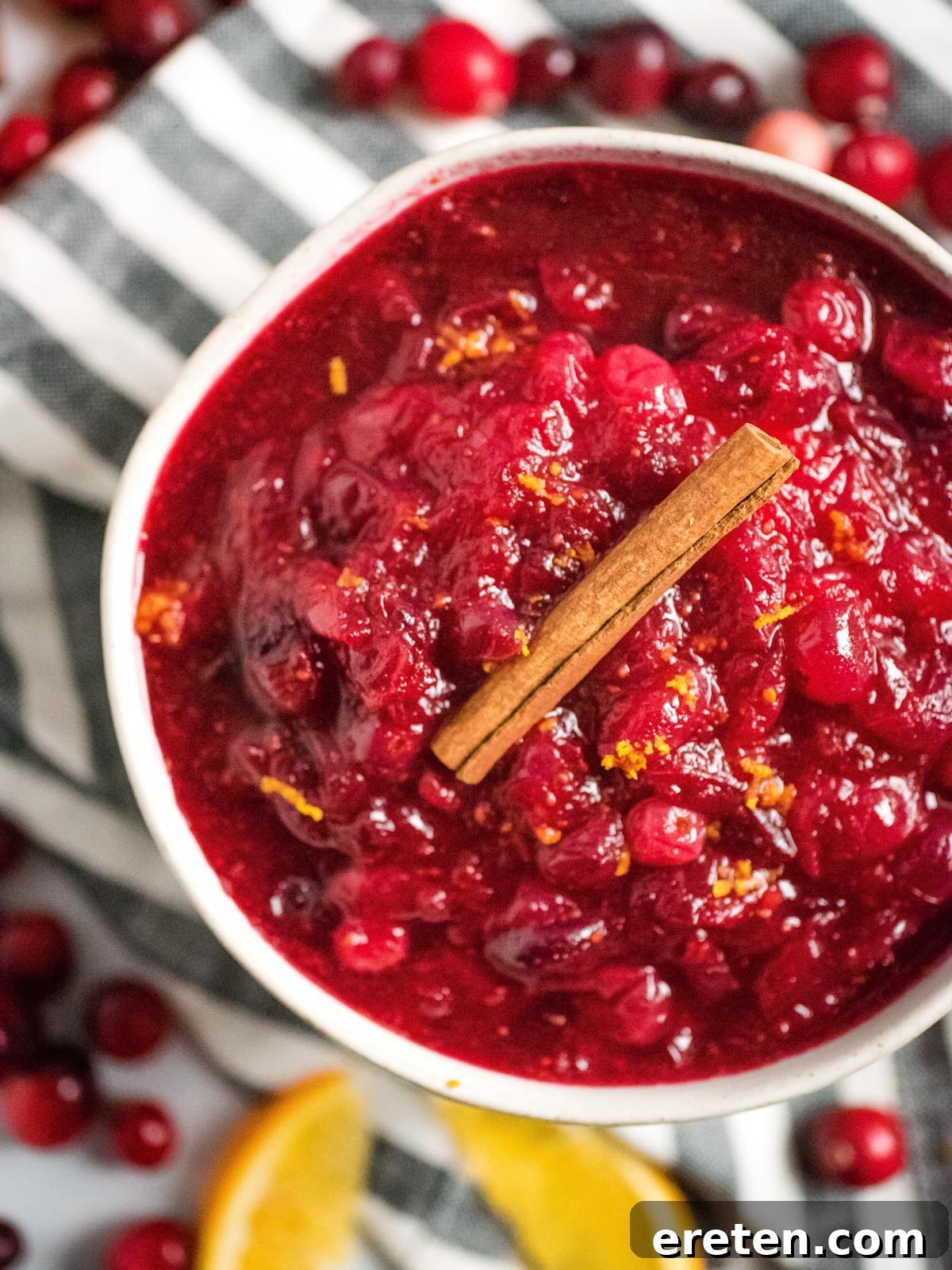 Vibrant Instant Pot Cranberry Orange Sauce 5 bowl full of instant pot cranberry sauce topped with a cinnamon stick