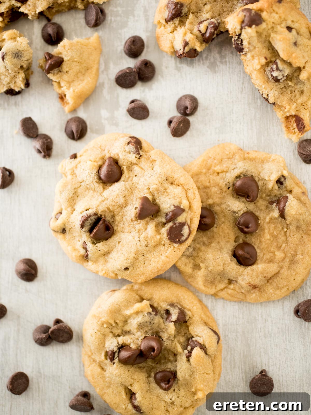 A beautiful stack of chewy chocolate chip cookies, artfully surrounded by loose chocolate chips, inviting indulgence