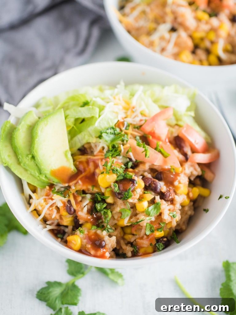 a white bowl full of instant pot chicken burrito bowl with toppings