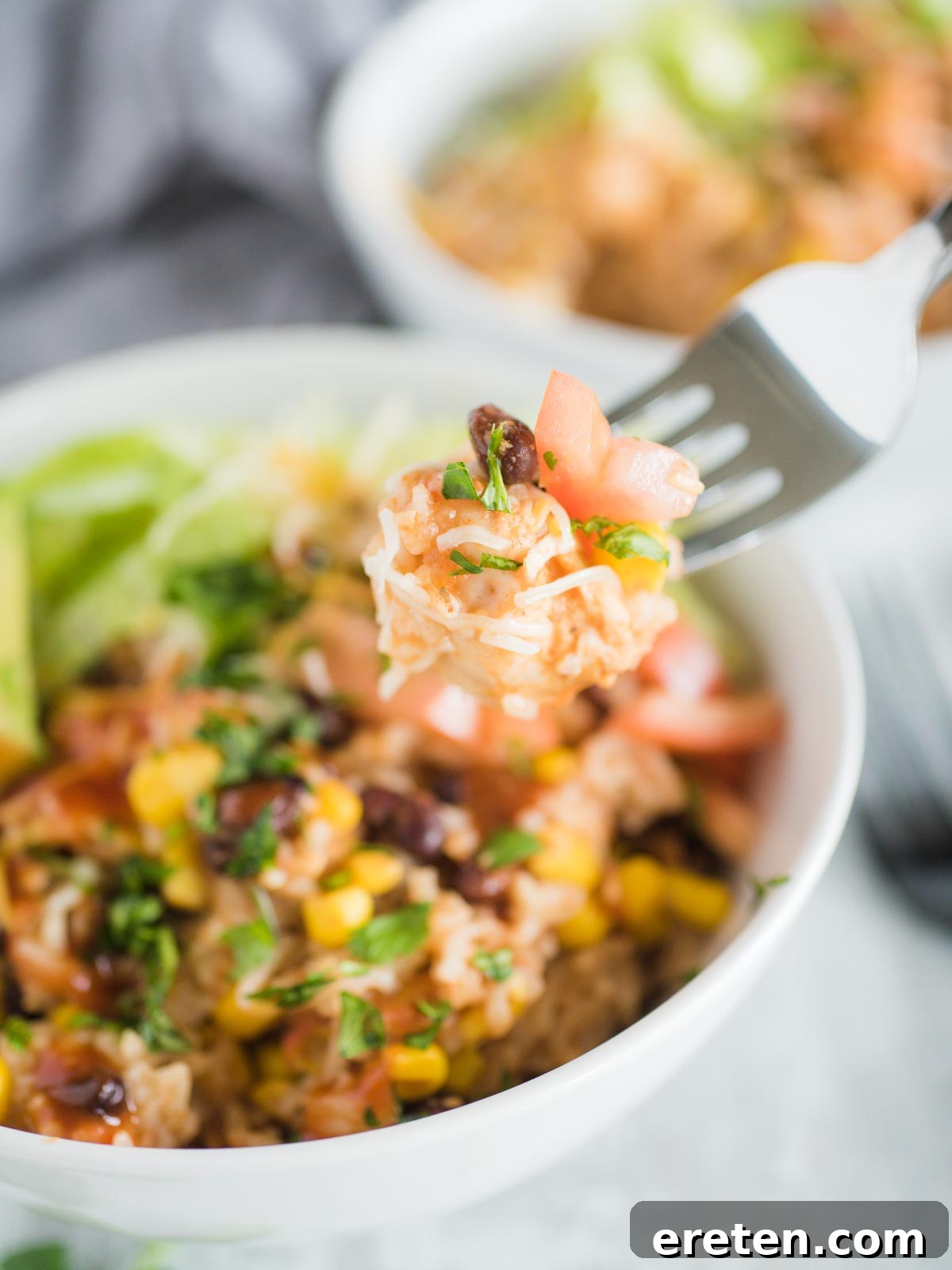 a fork with a bite of the burrito bowl on it