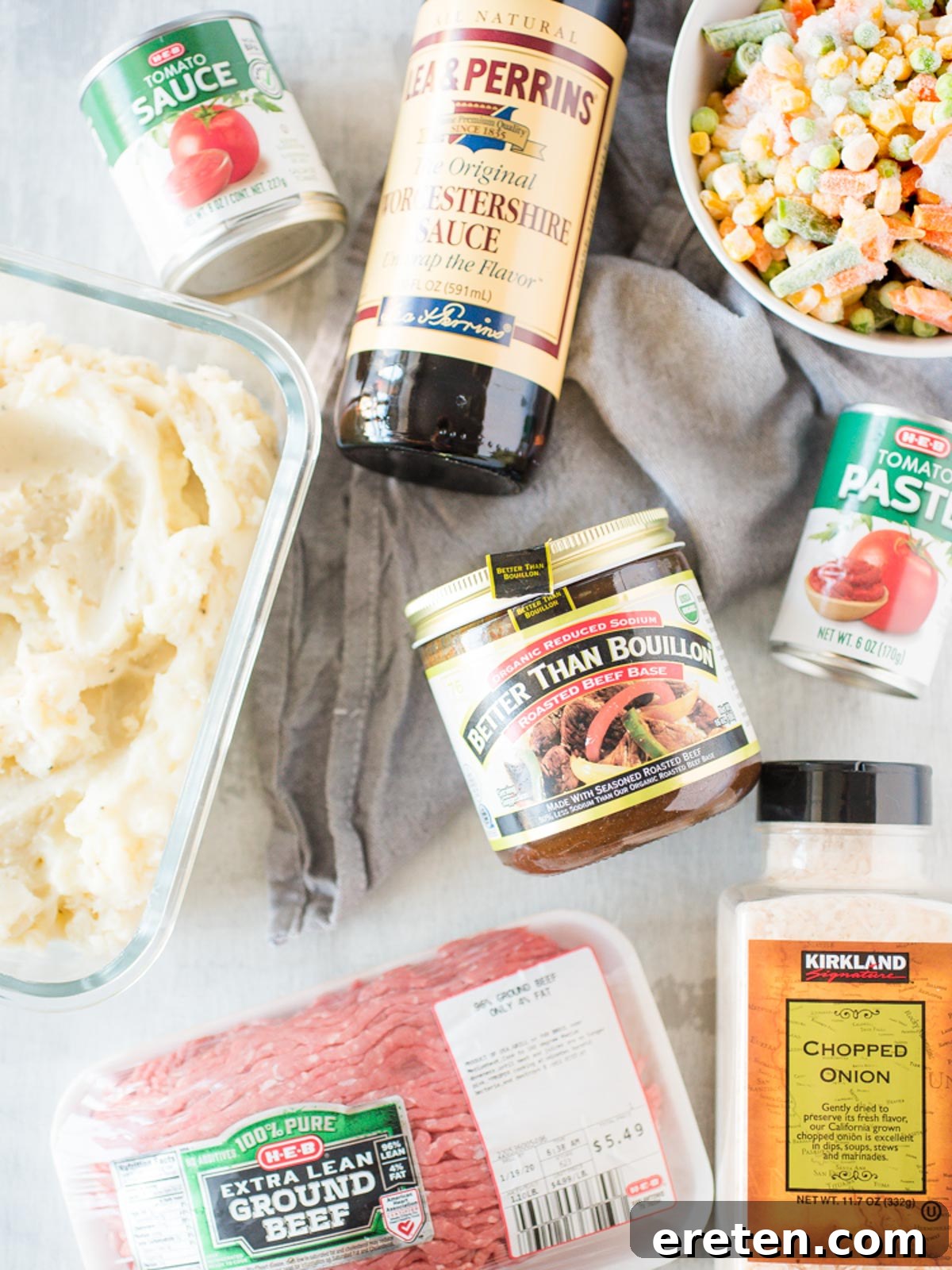 A flat lay of fresh ingredients for making Shepherd's Pie, including ground beef, vegetables, and seasonings.