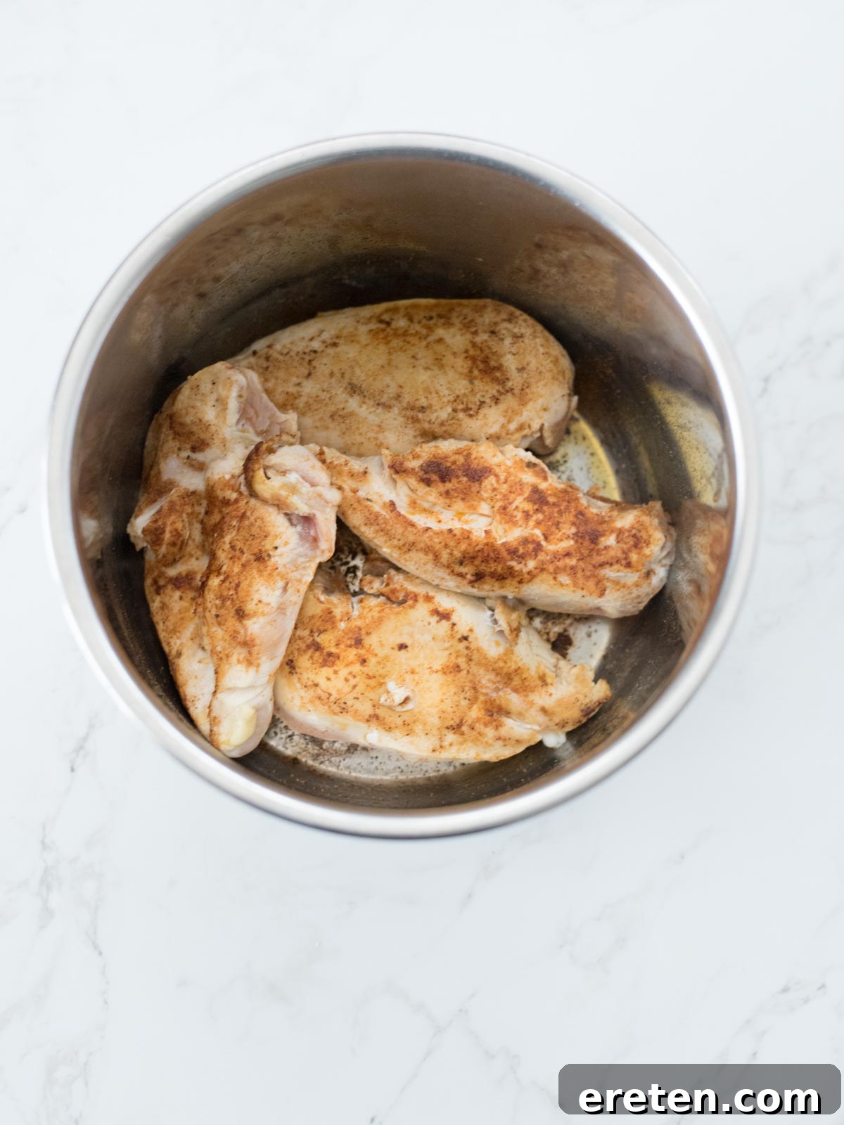 Raw chicken breasts seasoned with taco seasoning, placed neatly inside an Instant Pot, awaiting the next cooking step.