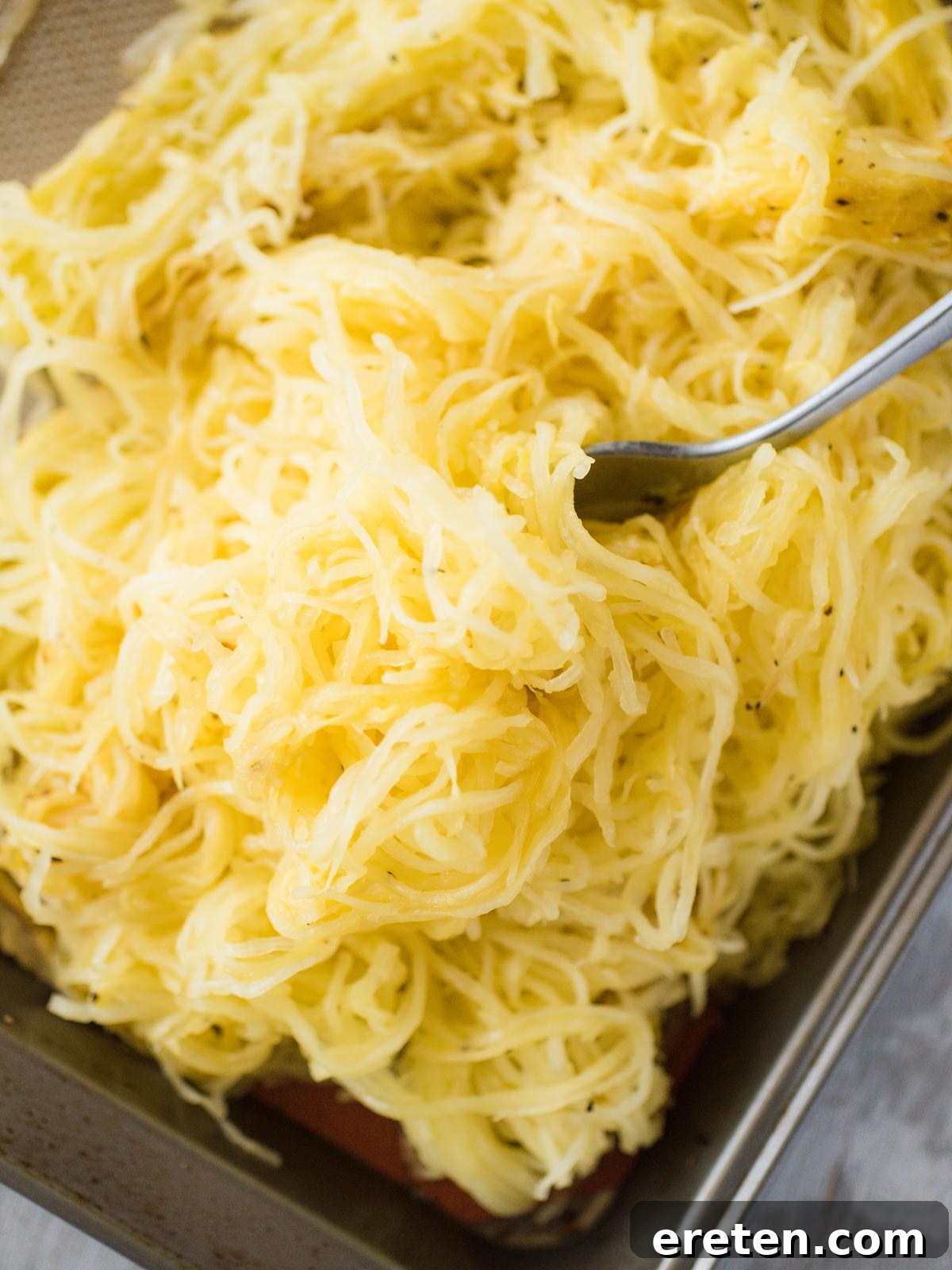 Perfect Oven Roasted Spaghetti Squash 3 a generous pile of perfectly roasted spaghetti squash strands with a fork resting on top
