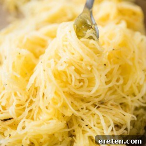 a pile of roasted spaghetti squash being twirled with a fork