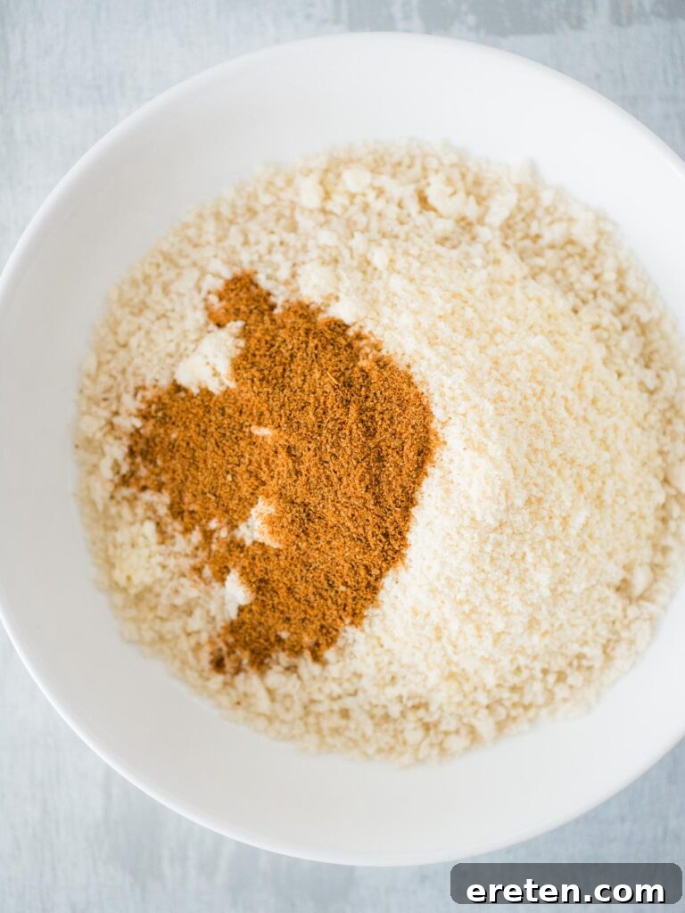 Close-up of panko breadcrumbs mixed with Parmesan cheese and Old Bay seasoning in a bowl, ready for breading.