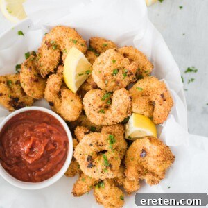 air fried shrimp in a bowl with dipping sauce topped with lemon