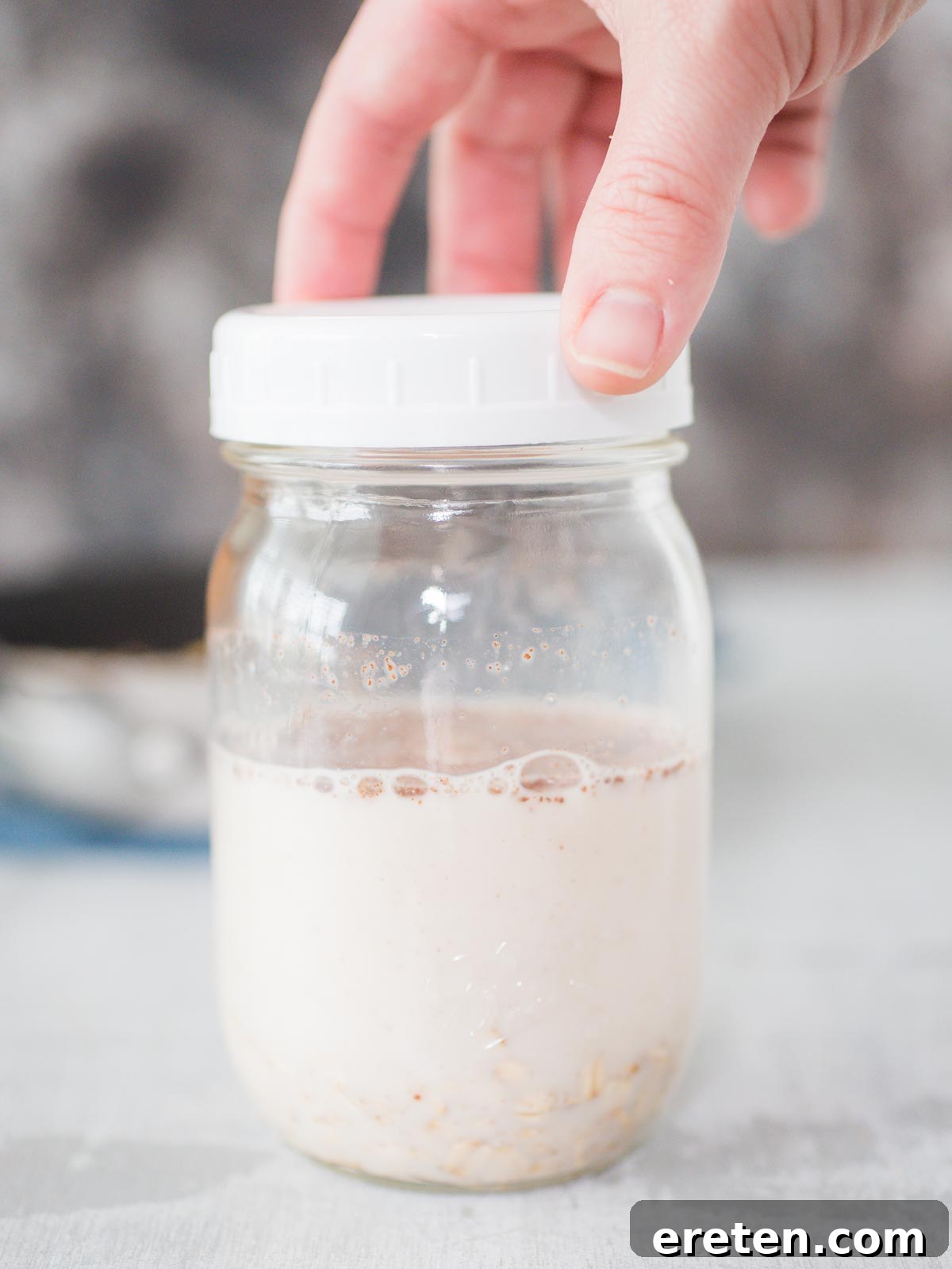 Lid being placed on a jar of overnight oats