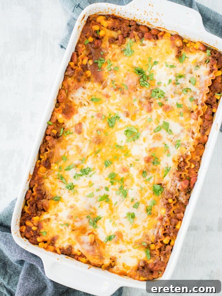 Kickin Tex Mex Lasagna 13 A baked Tex Mex lasagna, golden and bubbling in a casserole dish, ready to be sliced.