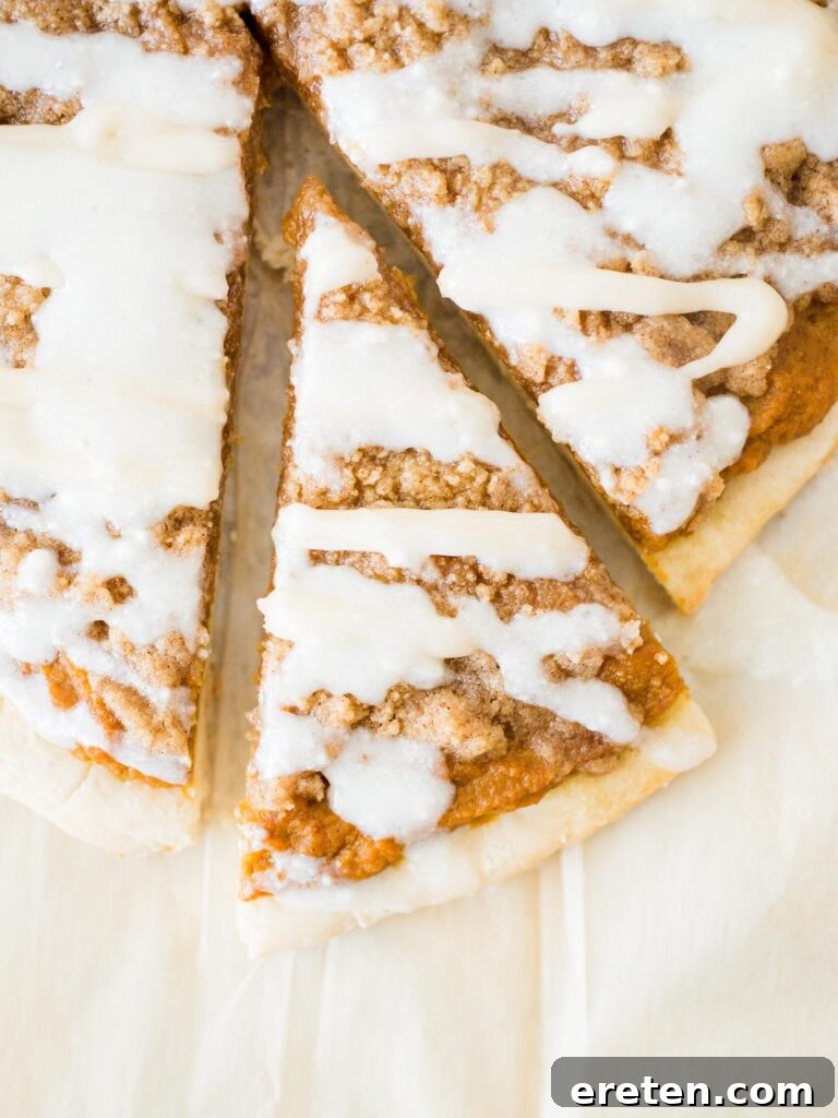 Sweet Pizza Creations: A Homemade Guide 2 A beautifully decorated slice of Pumpkin Dessert Pizza, showcasing its thin crust, pumpkin pie filling, streusel topping, and cream cheese drizzle.