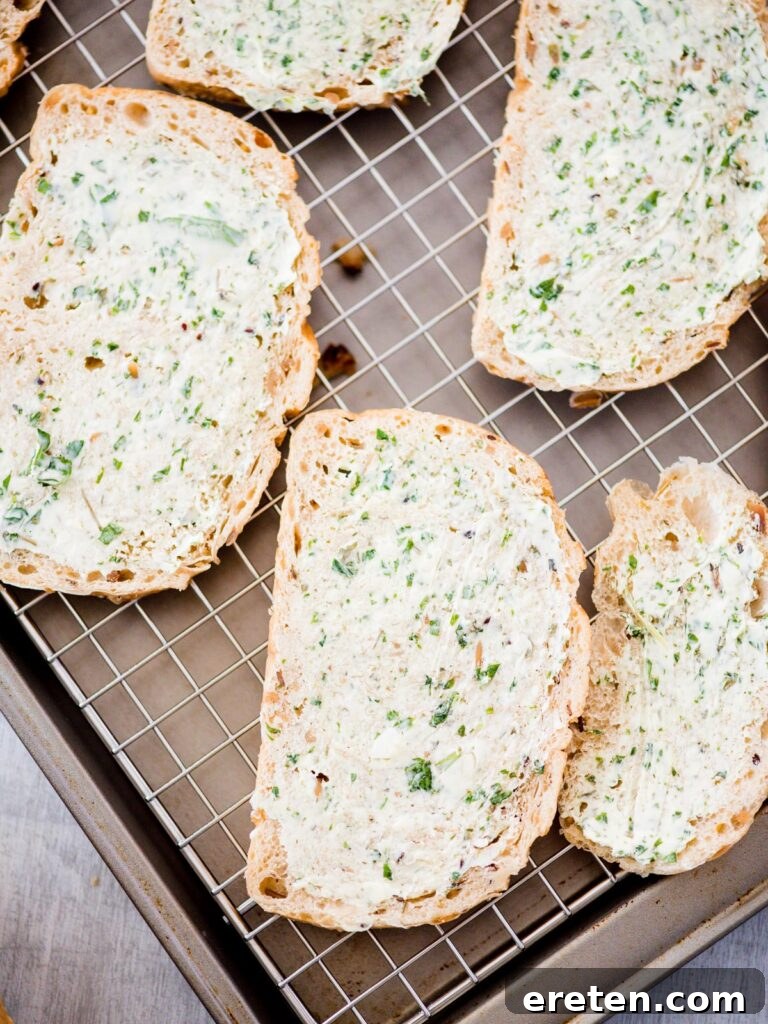 butter mixture spread on bread slices on pan