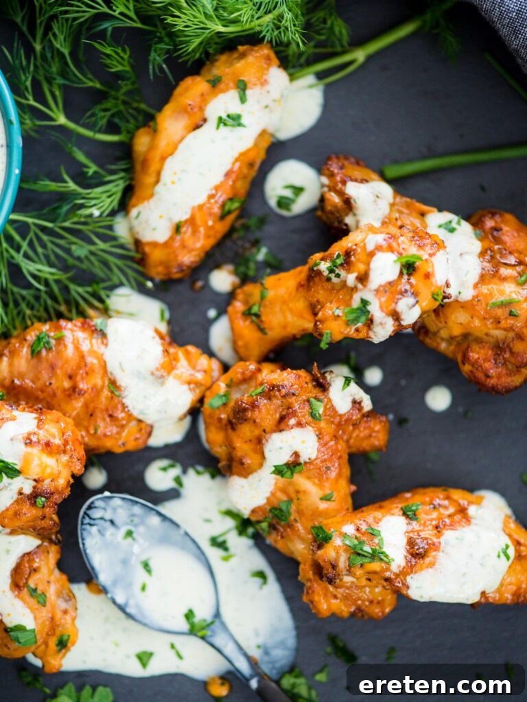 Crispy Air Fryer Dry Rub Wings 2 crispy chicken wings in the air fryer sprinkled with parsley and a ranch drizzle