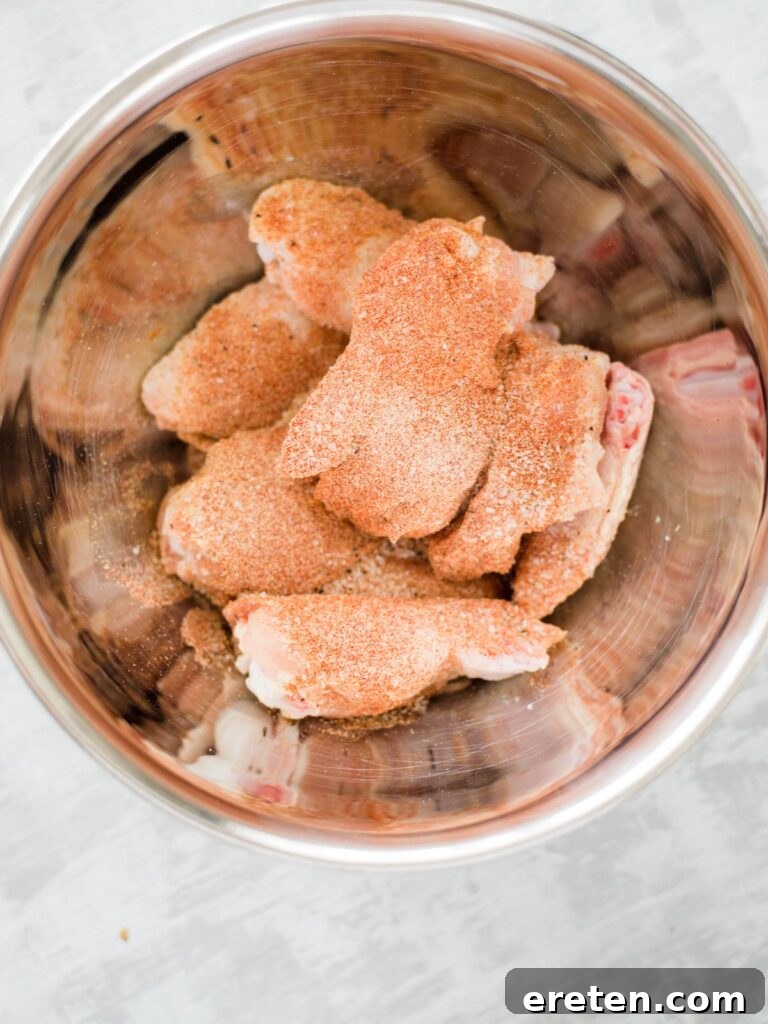 Crispy Air Fryer Dry Rub Wings 4 raw chicken wings with seasoning on them