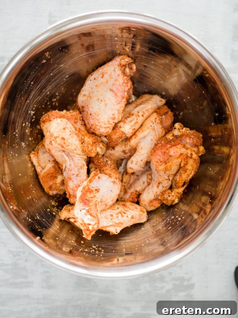 Crispy Air Fryer Dry Rub Wings 5 seasoned raw chicken wings in a bowl