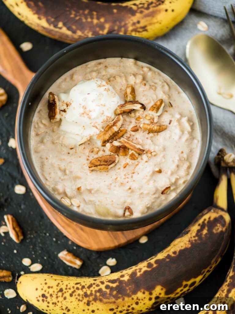 Creamy Banana Nut Bread Overnight Oats 2 A bowl of banana bread overnight oats, generously topped with crunchy pecans and a dollop of fluffy whipped cream, ready to be enjoyed.