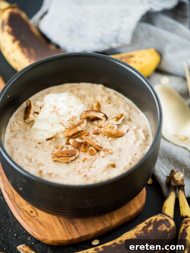 Creamy Banana Nut Bread Overnight Oats 13 A beautifully presented bowl of banana bread overnight oats, garnished with additional pecans and a swirl of whipped cream, inviting a delightful breakfast.