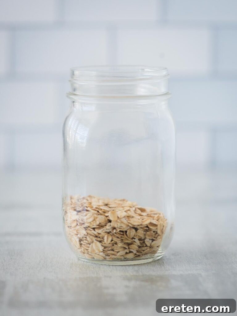 Creamy Banana Nut Bread Overnight Oats 4 Old-fashioned oats poured into a glass jar, ready for the next ingredients of the banana bread overnight oats recipe.