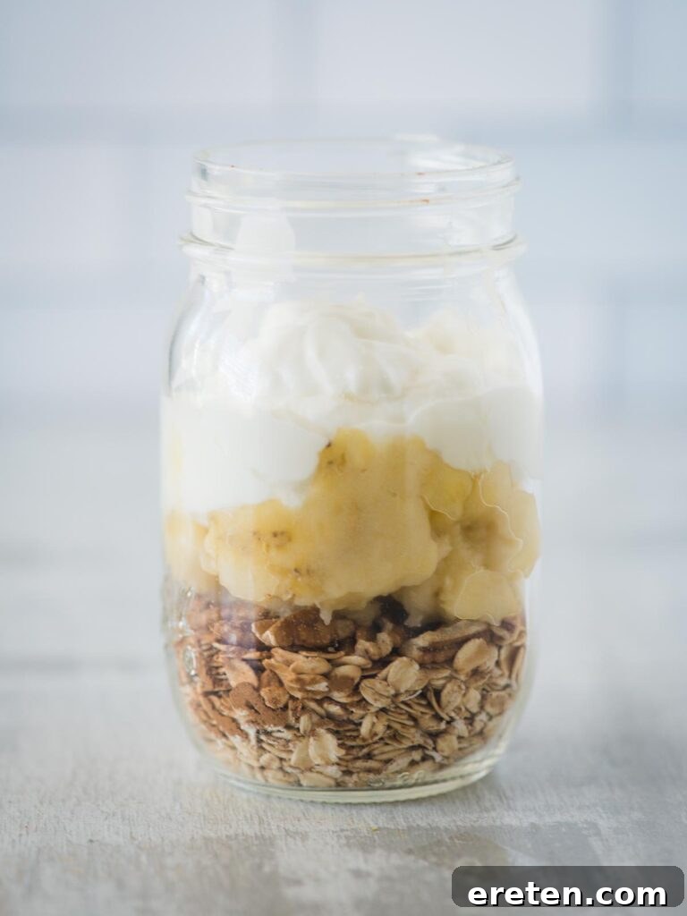 Creamy Banana Nut Bread Overnight Oats 8 A scoop of creamy Greek yogurt introduced into the jar, adding protein and a smooth texture to the banana bread overnight oats.