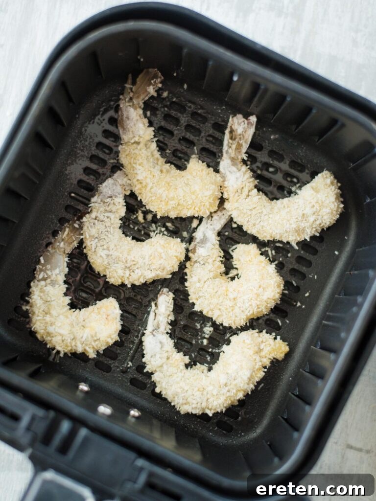 Breaded shrimp arranged in air fryer basket