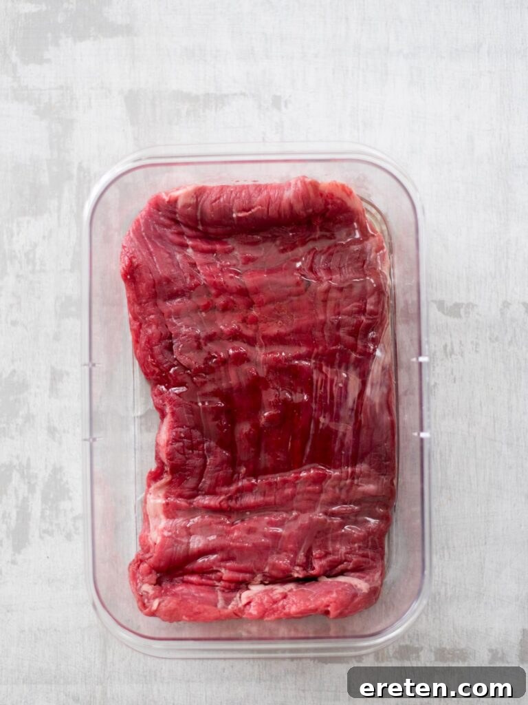 oil added to flank steak in container