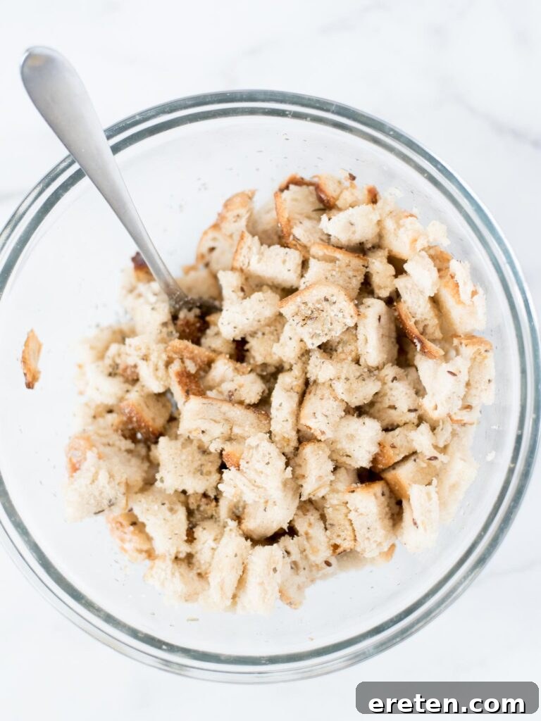 Bread being tossed in a mixing bowl with oil