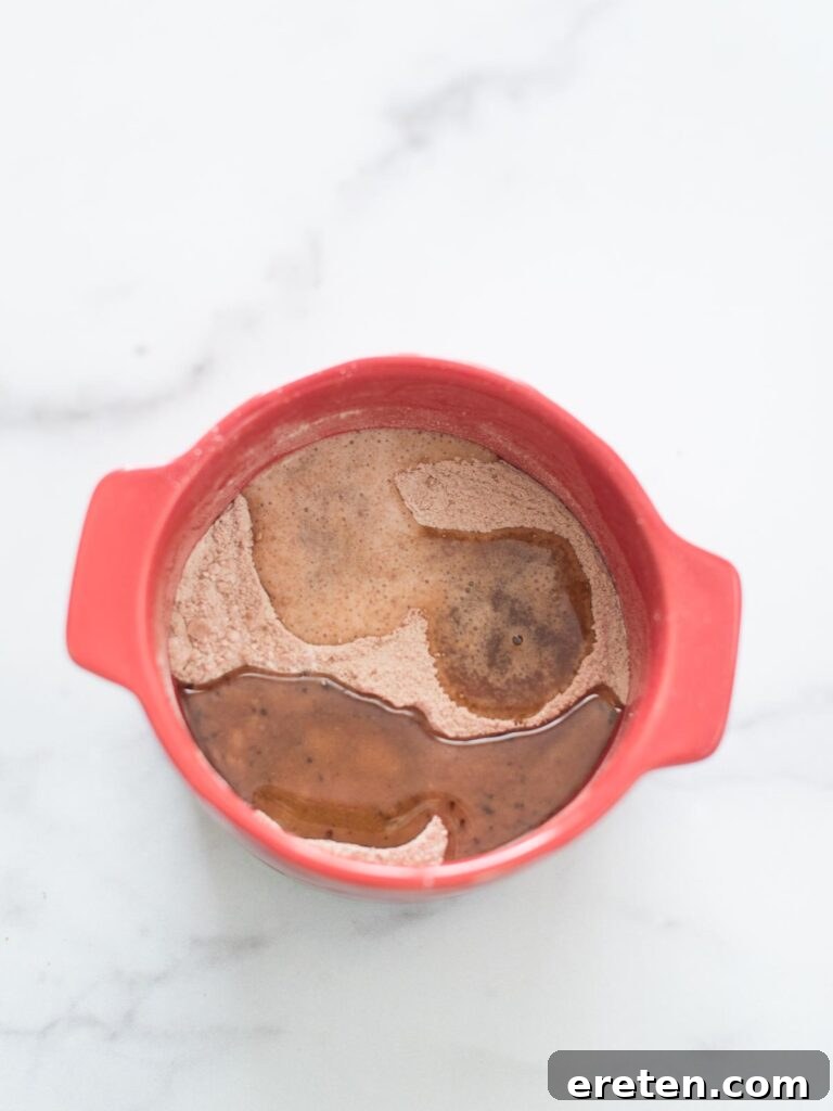 wet ingredients added to dry ingredients in mug