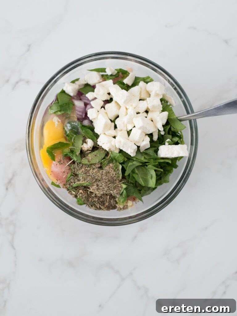 All ingredients for the Greek turkey burgers meticulously arranged in a large mixing bowl, awaiting combination.