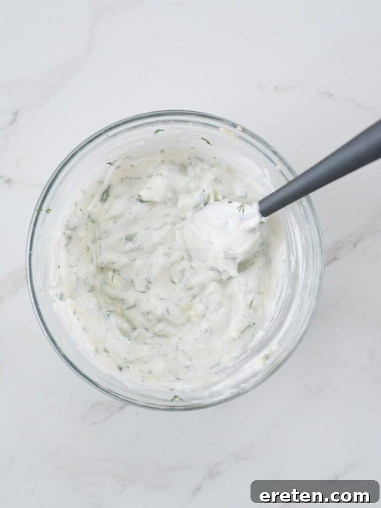 A perfectly blended bowl of creamy homemade tzatziki sauce, ready to be served as a refreshing accompaniment to Greek dishes.