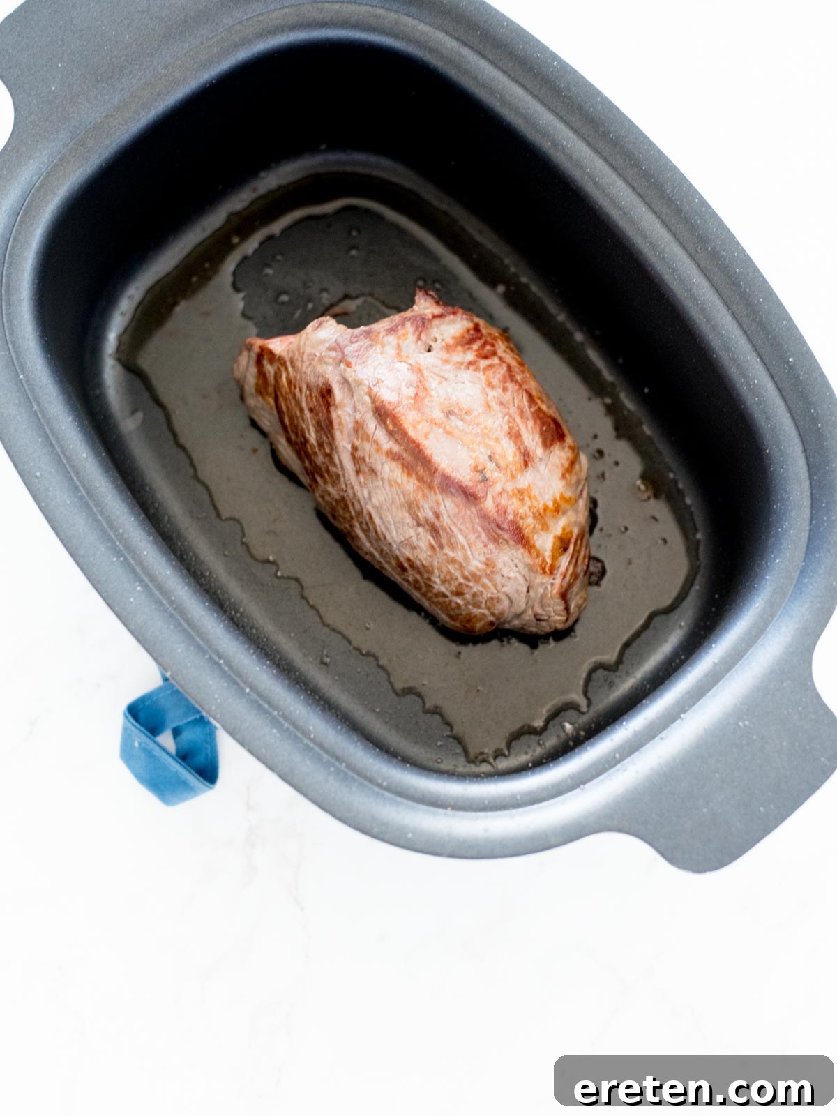 beef roast seared and sitting in crockpot