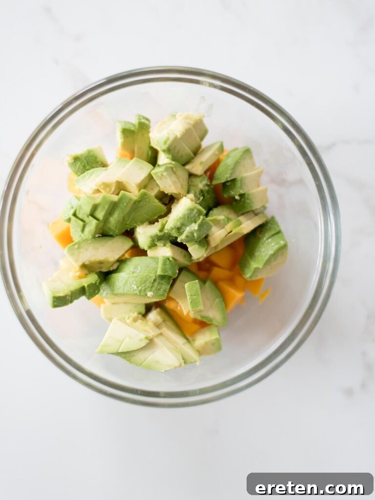 Freshly chopped avocado cubes in a mixing bowl with mango.