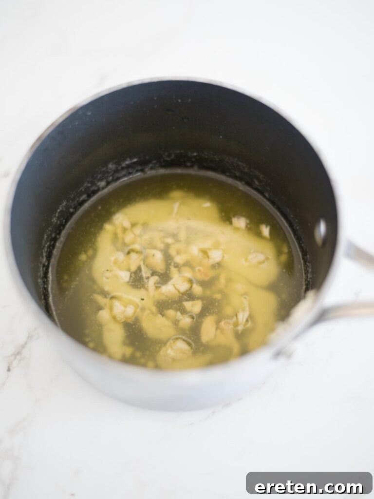 chopped garlic infusing in melted butter in a saucepan over low heat