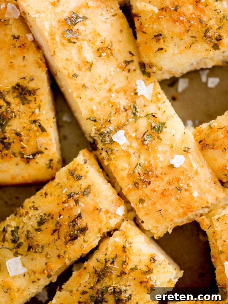 close-up of baked parmesan garlic breadsticks on a tray, ready to serve