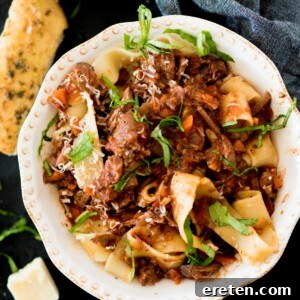 beef ragu over pasta topped with basil and parmesan
