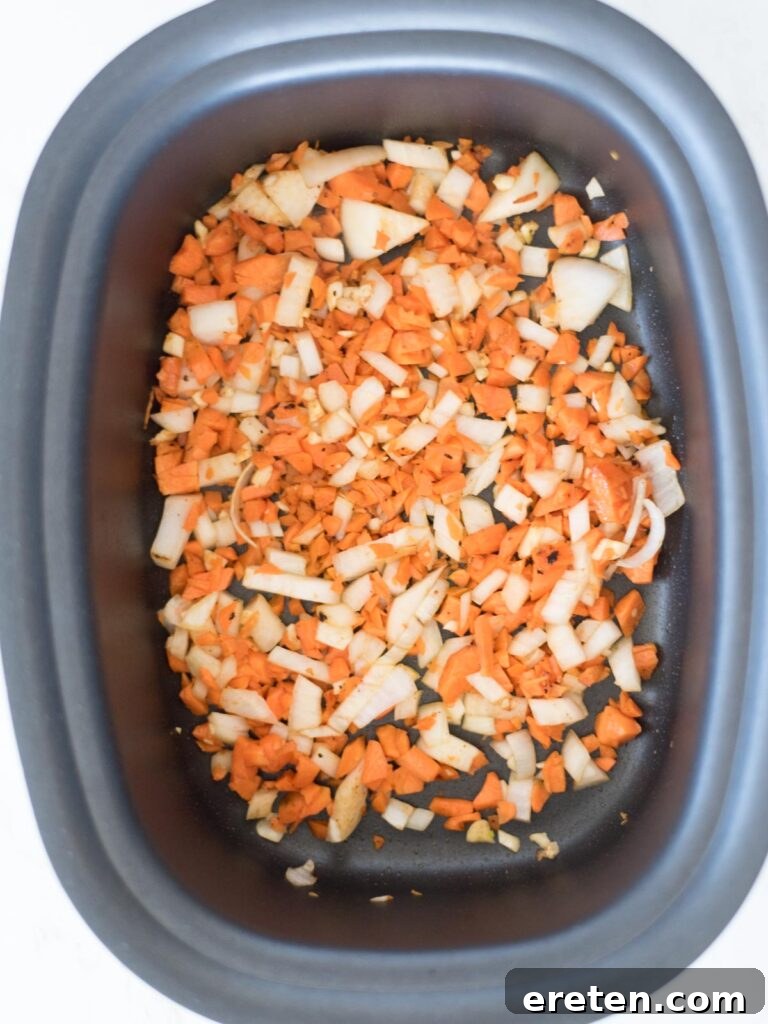 carrots, onion, and garlic being sautéed