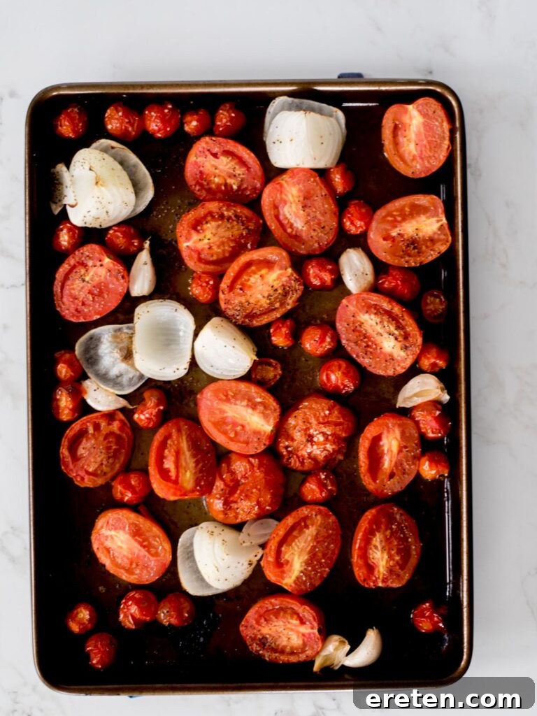 Comforting Roasted Tomato Basil Soup 5 Roasted tomatoes, onion, and garlic on a sheet pan, perfectly caramelized
