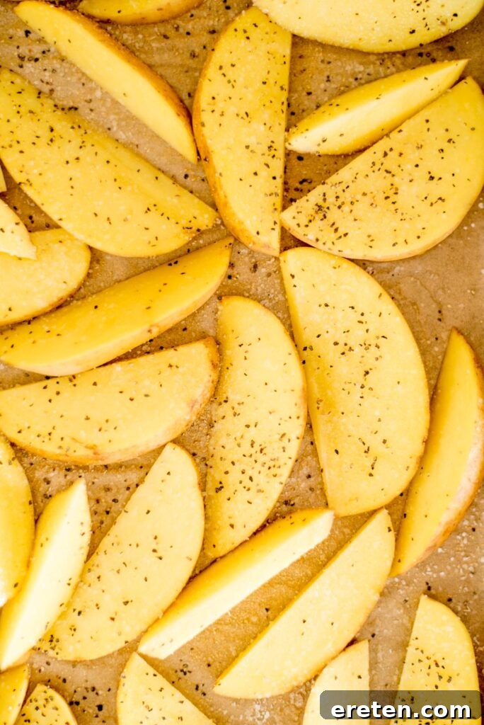 Another view of seasoned potato wedges, ready for the oven.